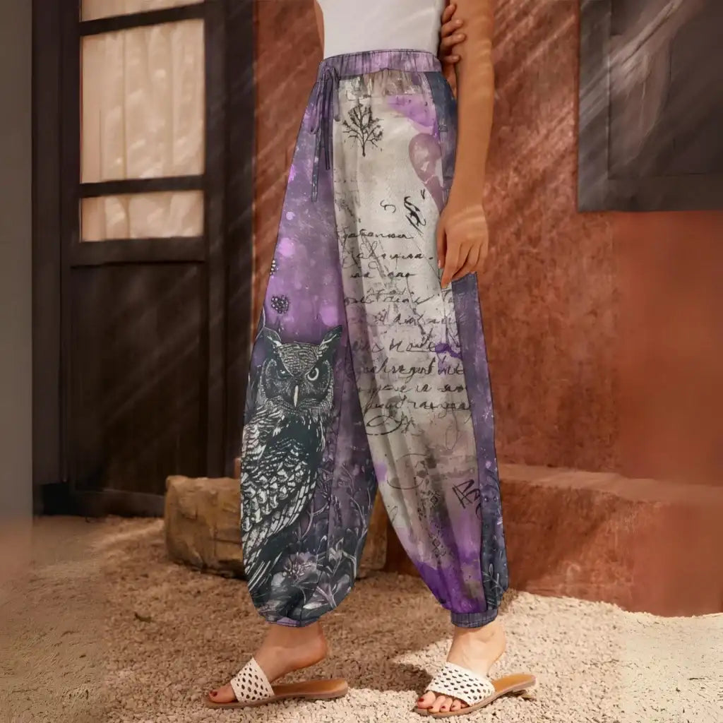 Loose-fitting harem pants with an owl and text print design in purple and gray tones, side view - ENCHANTED OWL HAREM PANTS WOMEN