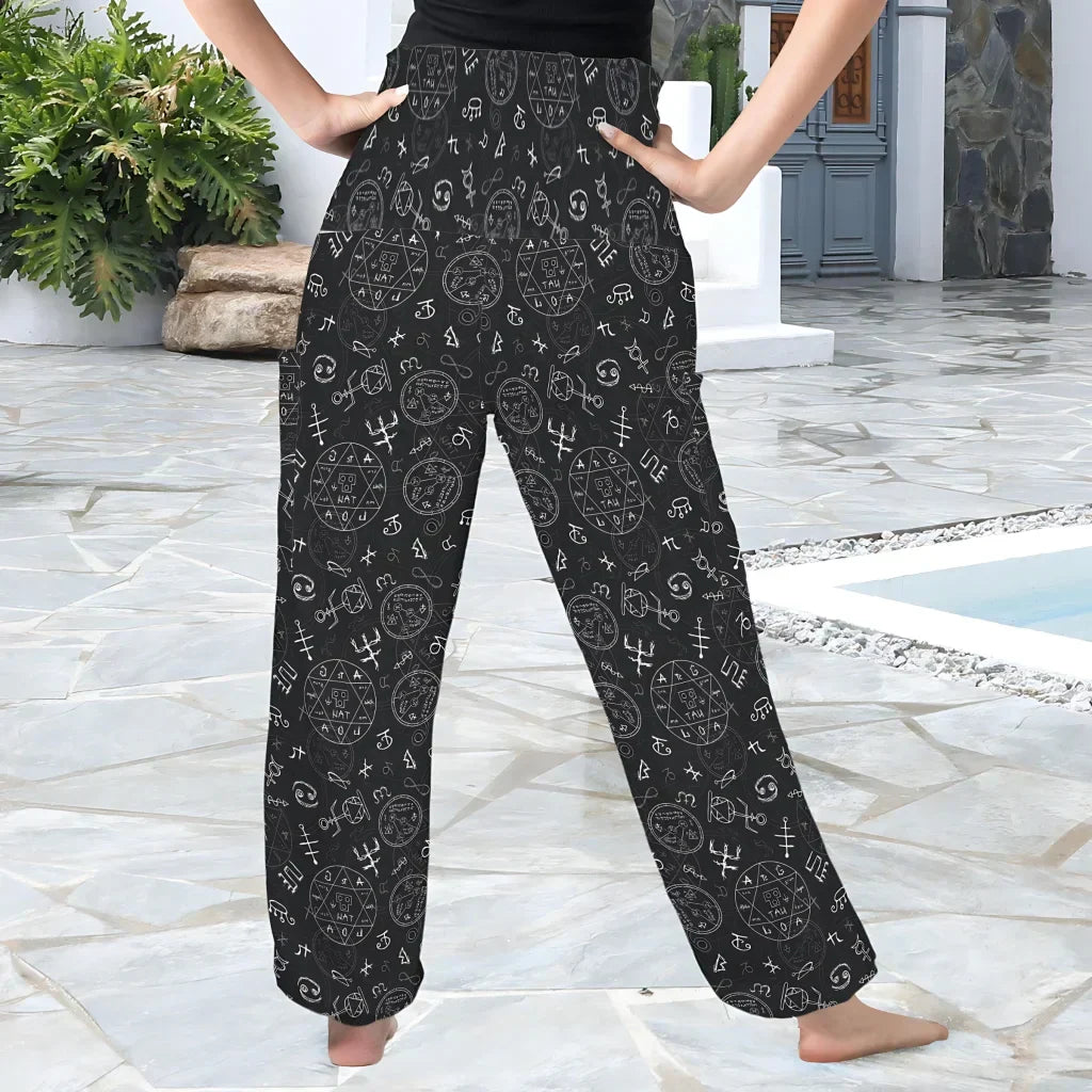 Black palazzo pants with white doodle-style cat face pattern, back view - MYSTIC OCCULT SMOCKED ALADDIN PANTS FOR LADIES