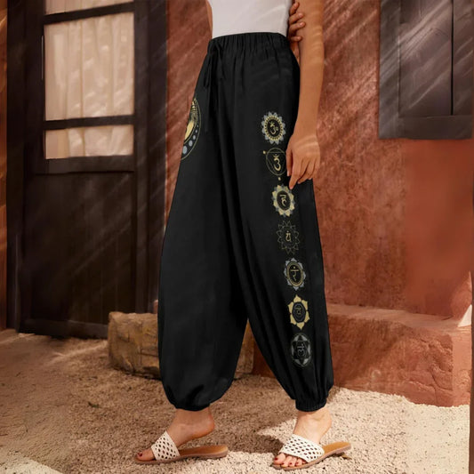 Black harem pants with decorative circular embroidered patterns down one leg, side view - MYSTICAL MOON HAREM PANTS WOMEN