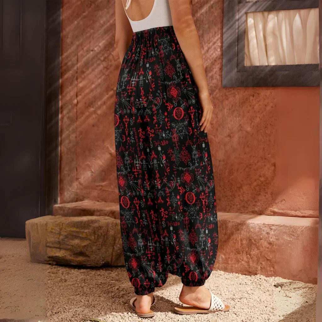 Flowy black harem pants with red floral print pattern and elastic cuffs at the ankles, back view - MYSTICAL SYMBOLS BLACK HAREM PANTS WOMEN FOR YOGA PRACTICE