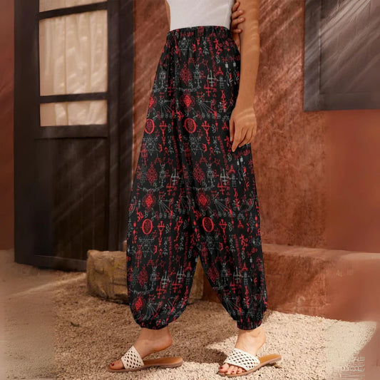 Flowy black harem pants with red floral print pattern and elastic cuffs at the ankles, side view - MYSTICAL SYMBOLS BLACK HAREM PANTS WOMEN FOR YOGA PRACTICE