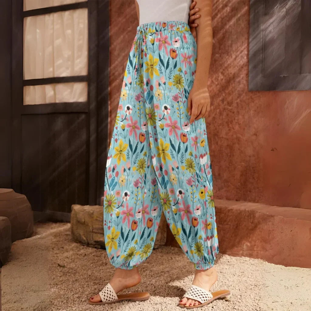 Light blue floral harem pants with an elastic waistband and ankle cuffs, side view - SEAMLESS DOODLE FLORAL HAREM PANTS WOMEN