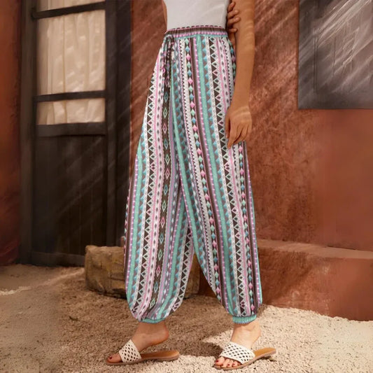 Loose-fitting patterned pants with vertical stripes in turquoise, red, and white, side view - VIBRANT BOHEMIAN STRIPED HAREM PANTS WOMEN